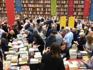 Eveniment literar cu participanți citind și discutând cărți.